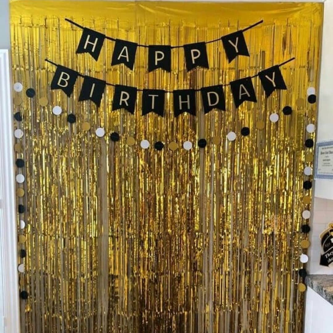 Gold sequin backdrop with a black birthday banner and circular decorations.