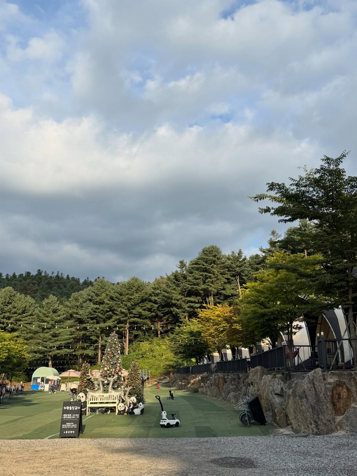 White dome tents nestled among green trees in a scenic outdoor camping area.