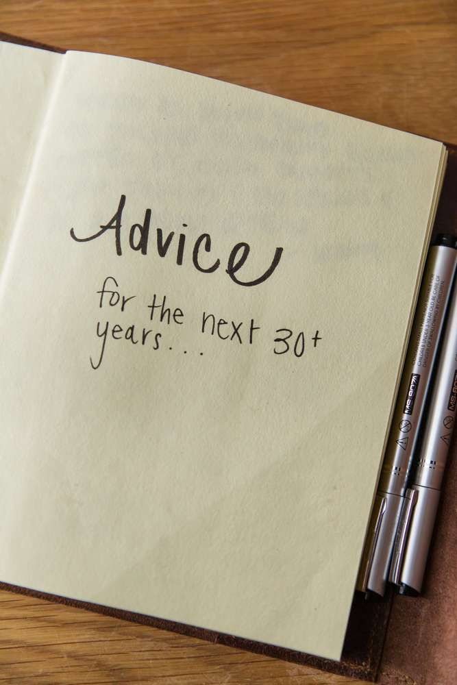 An open notebook on a wooden table with handwritten advice for the next thirty years.
