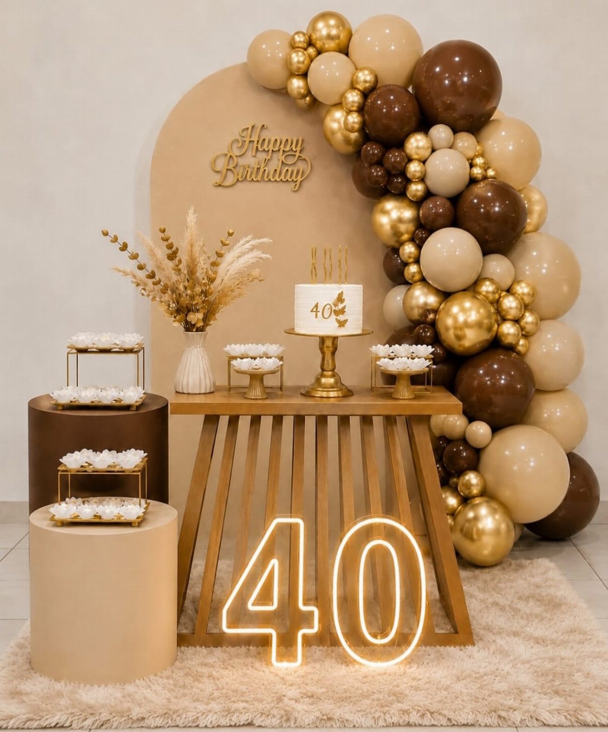 A dessert table with a cake, gold and brown balloons, and a neon 40 sign.