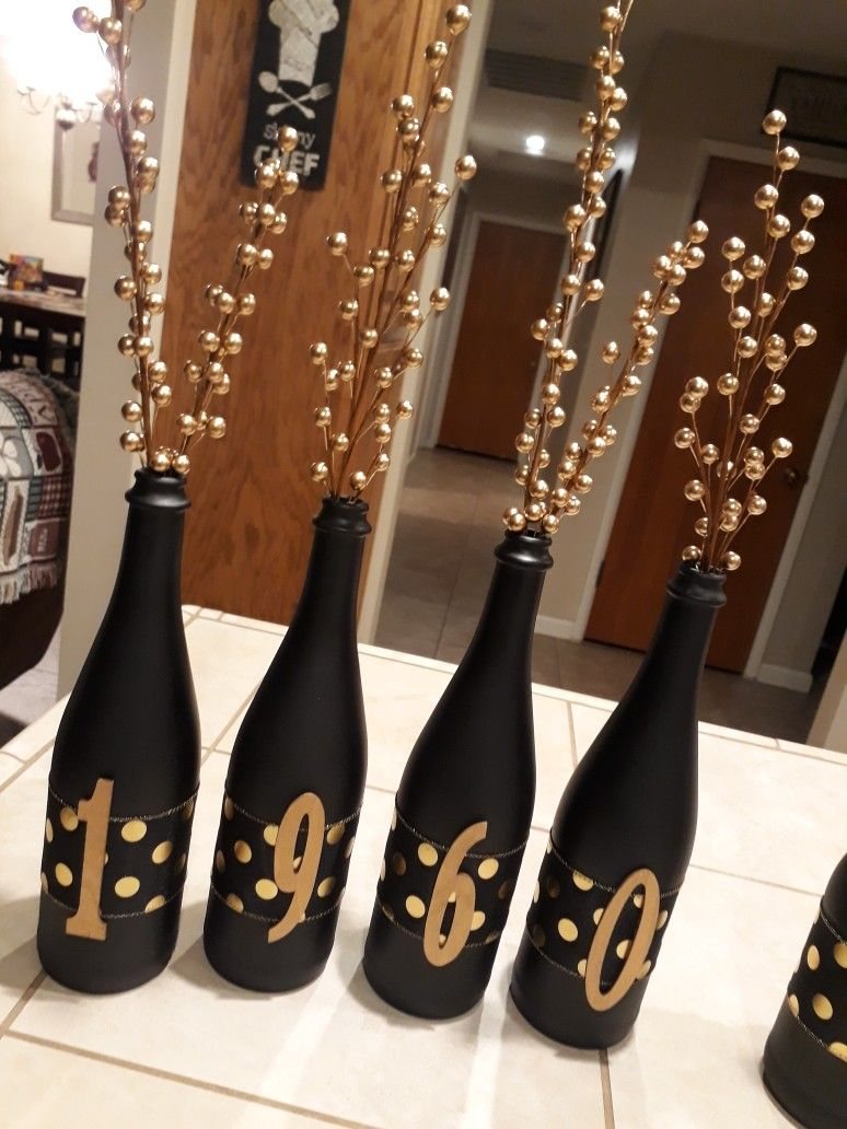 Black bottles with gold polka dots and numbers spelling 1960 with gold beaded branches.