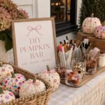 Decorated white pumpkins and craft supplies arranged on a table for a DIY pumpkin bar activity.
